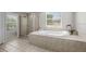 Bright bathroom featuring a soaking tub and a separate glass-enclosed shower at 9223 Brindlewood Dr, Odessa, FL 33556