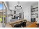 Dining area with a wooden table, a modern chandelier, hardwood floors, and access to the kitchen at 9223 Brindlewood Dr, Odessa, FL 33556