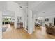 Bright entryway featuring hardwood floors, white walls, staircase, and views into the dining and living rooms at 9223 Brindlewood Dr, Odessa, FL 33556