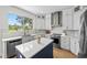 Bright kitchen featuring white cabinets, stainless steel appliances, a center island, and hardwood floors at 9223 Brindlewood Dr, Odessa, FL 33556