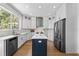 Modern kitchen with white cabinets, stainless steel appliances, a blue island, and hardwood floors at 9223 Brindlewood Dr, Odessa, FL 33556