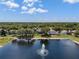 Scenic lake view featuring a fountain, lush greenery, mature trees, and several homes with backyard pools at 9223 Brindlewood Dr, Odessa, FL 33556