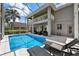 Inviting screened-in pool area with comfortable lounge chairs and an upstairs balcony overlooking the outdoor space at 9223 Brindlewood Dr, Odessa, FL 33556