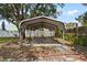 Spacious metal carport providing covered parking, with a partial view of the surrounding backyard at 9810 N 53Rd St, Temple Terrace, FL 33617
