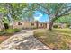Attractive single-story house featuring a brick accent wall, white shutters, and a beautiful paver driveway at 9810 N 53Rd St, Temple Terrace, FL 33617