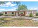 Charming single-story home featuring a brick facade, white shutters, and a well-manicured front yard at 9810 N 53Rd St, Temple Terrace, FL 33617