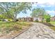 Inviting single-story home with brick details, white shutters, and a paver driveway lined with greenery at 9810 N 53Rd St, Temple Terrace, FL 33617