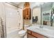 Bright bathroom featuring a vanity with drawers, toilet, wood storage cabinet and a shower-tub combo at 10313 Scarlet Chase Dr, Riverview, FL 33569