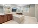 Spacious Primary bathroom with dual vanities, soaking tub, separate shower, and a wall-mounted TV at 10313 Scarlet Chase Dr, Riverview, FL 33569