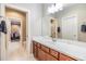 Long bathroom vanity with cabinets and sink, a large mirror, and an adjoining toilet room and closet at 10313 Scarlet Chase Dr, Riverview, FL 33569