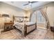 Bedroom with wood flooring, a bed, area rug, side table, lamps, and a window with shutters at 10313 Scarlet Chase Dr, Riverview, FL 33569