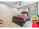 Bedroom features a bed with storage drawers, a window with shutters, and an interesting area rug at 10313 Scarlet Chase Dr, Riverview, FL 33569