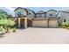 Two story exterior of home with 3-car garage and covered porch, with well manicured yard at 10313 Scarlet Chase Dr, Riverview, FL 33569