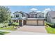 Inviting two-story home with a three car garage and manicured landscaping at 10313 Scarlet Chase Dr, Riverview, FL 33569