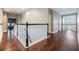 Second story hallway featuring hardwood floors, white railings, and doorways leading to other rooms at 10313 Scarlet Chase Dr, Riverview, FL 33569