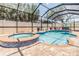 Outdoor screened-in pool with a spa, surrounded by brick pavers and a privacy fence at 10313 Scarlet Chase Dr, Riverview, FL 33569