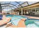 Screened-in pool with integrated spa, brick coping, and an outdoor seating area with a bar at 10313 Scarlet Chase Dr, Riverview, FL 33569