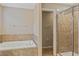 Relaxing bathroom featuring a soaking tub with tile surround and a glass shower at 10808 Whitecap Dr, Riverview, FL 33579
