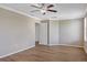 Spacious bedroom with wood-look floors, crown molding, ceiling fan and adjacent door to another room at 10808 Whitecap Dr, Riverview, FL 33579