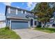 Two-story home featuring a blue exterior, a two-car garage, and light shutters at 10808 Whitecap Dr, Riverview, FL 33579