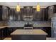 Spacious kitchen features dark cabinets, granite countertops, stainless steel appliances, and stylish pendants at 10808 Whitecap Dr, Riverview, FL 33579