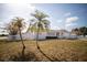 Charming single story home with an attached garage and two palm trees in the front at 11071 141St St, Largo, FL 33774