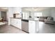 Open kitchen featuring a granite island with a stainless steel dishwasher and white cabinetry at 11071 141St St, Largo, FL 33774