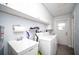 Clean laundry room featuring a washing machine, dryer, sink, and overhead cabinets at 11071 141St St, Largo, FL 33774