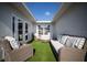 Enclosed patio area with wicker furniture and artificial grass for relaxing at 11071 141St St, Largo, FL 33774