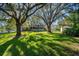 A spacious backyard featuring lush lawn, mature trees, and a hanging swing at 11109 Winn Rd, Riverview, FL 33569