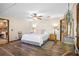 Bright main bedroom featuring a queen-sized bed, ceiling fan, and hardwood floors at 11109 Winn Rd, Riverview, FL 33569