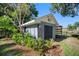 This shed has a double door entry, an exterior light, and a mature landscape at 11109 Winn Rd, Riverview, FL 33569