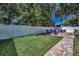 Large backyard with green lawn, white fence, and brick patio seating area at 112 W Sligh Ave, Tampa, FL 33604