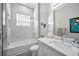 Bright bathroom with marble tile, glass shower door, tub, and white vanity at 112 W Sligh Ave, Tampa, FL 33604