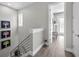 Bright hallway with modern staircase, art, wood flooring, and an open doorway at 112 W Sligh Ave, Tampa, FL 33604