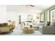 Bright living room with an L-shaped couch, round rug coffee table, green walls, and open concept layout at 12442 Radiant Crystal Rose, Parrish, FL 34219