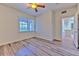 Well-lit bedroom with wood-look floors, fan and bright window, with doorway to the kitchen at 13025 Sanctuary Cove Dr # 301, Temple Terrace, FL 33637