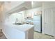 Bright kitchen features a peninsula with sink, white countertops, and appliances at 13025 Sanctuary Cove Dr # 301, Temple Terrace, FL 33637