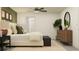 Bright bedroom with stylish furniture, ceiling fan, and a doorway leading to the bathroom at 13138 Empress Jewel Trl, Parrish, FL 34219