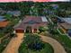 Aerial view of luxury home with lush landscaping, circular driveway, and a private residential neighborhood at 132 Giralda Ne Blvd, St Petersburg, FL 33704