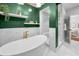 Bright bathroom with a soaking tub, open shelving, marble tile, and gold finishes in a renovated home at 132 Giralda Ne Blvd, St Petersburg, FL 33704