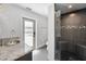 Modern bathroom featuring a walk-in shower with pebble floor and a vanity with granite countertop at 132 Giralda Ne Blvd, St Petersburg, FL 33704