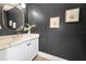Stylish powder room with a quartz countertop vanity, dark accent wall, and modern fixtures at 132 Giralda Ne Blvd, St Petersburg, FL 33704