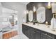 Contemporary bathroom features a double vanity, gold fixtures, and a view into the primary bedroom at 132 Giralda Ne Blvd, St Petersburg, FL 33704
