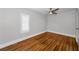 Sunlit bedroom with hardwood floors, a modern ceiling fan, and a large shuttered window at 132 Giralda Ne Blvd, St Petersburg, FL 33704