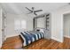 Cozy bedroom with built-in shelving, hardwood floors, ceiling fan, and shuttered windows at 132 Giralda Ne Blvd, St Petersburg, FL 33704