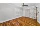 Bright bedroom featuring hardwood floors, a ceiling fan, shuttered windows, and a double-door closet at 132 Giralda Ne Blvd, St Petersburg, FL 33704