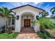 Stunning home featuring a covered entryway with double doors, stone pathway, and well-maintained landscaping at 132 Giralda Ne Blvd, St Petersburg, FL 33704