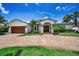 Charming single-Gathering home featuring a brick driveway, attached garage, and a well-manicured lawn at 132 Giralda Ne Blvd, St Petersburg, FL 33704