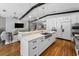 Modern kitchen flowing into the living room, featuring marble counters, an island, and wood floors at 132 Giralda Ne Blvd, St Petersburg, FL 33704